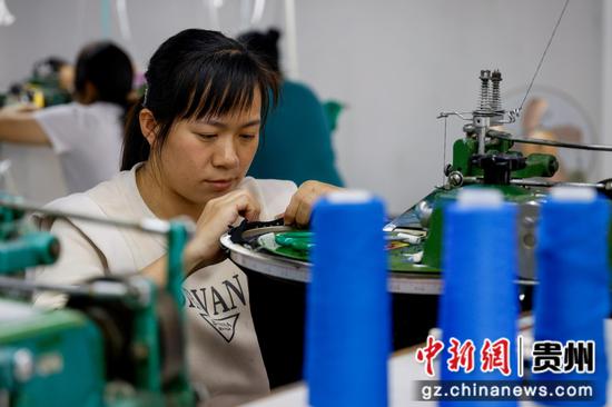 2024年10月8日，工人在贵州省黔南布依族苗族自治州罗甸县工业园区一家民族服饰企业加工服饰产品。