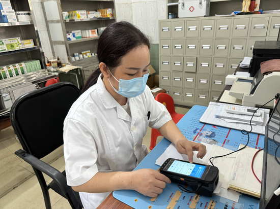 村医使用“村医通”设备为参保人员结算门诊慢特病费用。