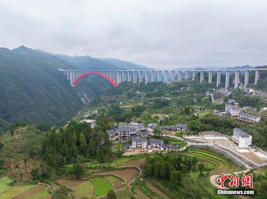 图为10月20日，航拍大发渠特大桥与团结村相互映衬，构成一幅美丽的乡村画卷。（无人机照片）