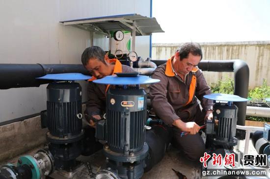 现场工人正在安装调试电子循环泵。朱芸 摄 现场工人正在安装调试电子循环泵。朱芸 摄