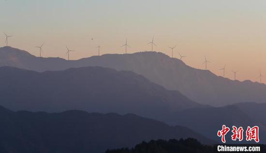 图为从江县秀塘壮族乡,矗立于山巅的风力发电机与山林、朝霞相映成景。罗京来 摄 图为从江县秀塘壮族乡,矗立于山巅的风力发电机与山林、朝霞相映成景。罗京来 摄