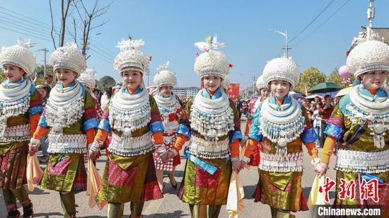 图为黄平“芦笙会”现场，当地苗族歌手阿幼朵(左三)与同伴展示苗族服饰、银饰。伍卫东摄