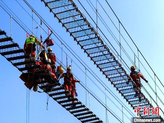 图为湖南省消防救援总队湘西支队天坑洞穴救援专业队在进行游乐设施高空救援演练。中新网记者 袁超 摄 图为湖南省消防救援总队湘西支队天坑洞穴救援专业队在进行游乐设施高空救援演练。中新网记者 袁超 摄
