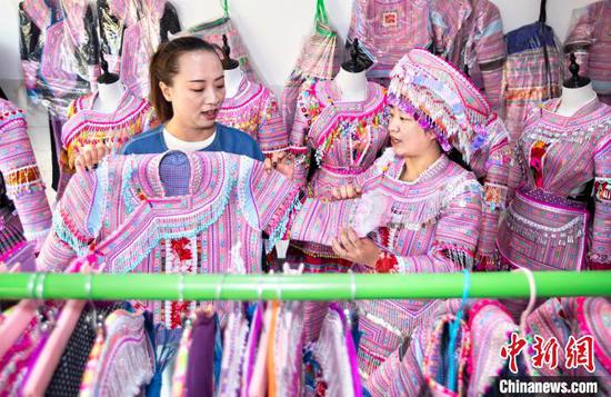 图为顾客在渔塘村选购苗族服饰。史开心 摄 图为顾客在渔塘村选购苗族服饰。史开心 摄