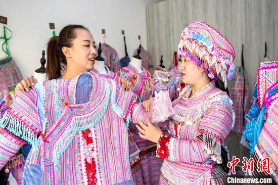 图为顾客在渔塘村选购苗族服饰。史开心 摄 图为顾客在渔塘村选购苗族服饰。史开心 摄