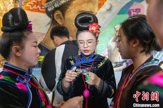 图为来自雷山县的苗族绣娘与当地侗族绣娘在高增村交流手工刺绣技艺。吴德军 摄 图为来自雷山县的苗族绣娘与当地侗族绣娘在高增村交流手工刺绣技艺。吴德军 摄