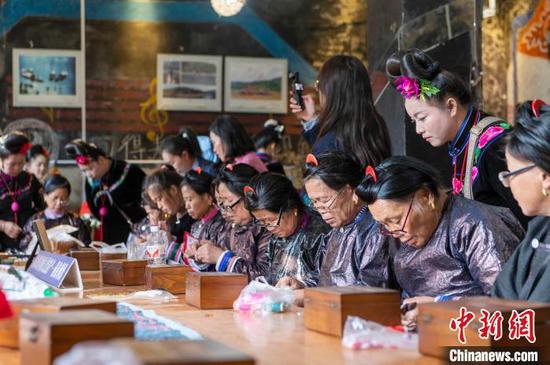 图为来自雷山县的苗族绣娘与当地侗族绣娘在高增村交流手工刺绣技艺。吴德军 摄 图为来自雷山县的苗族绣娘与当地侗族绣娘在高增村交流手工刺绣技艺。吴德军 摄