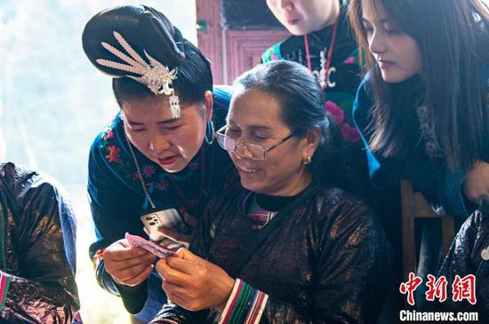图为来自雷山县的苗族绣娘与当地侗族绣娘在高增村交流手工刺绣技艺。吴德军 摄 图为来自雷山县的苗族绣娘与当地侗族绣娘在高增村交流手工刺绣技艺。吴德军 摄