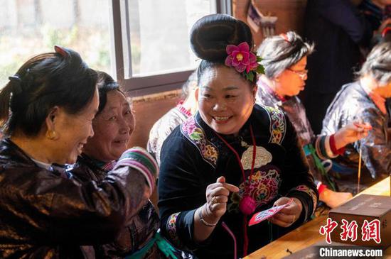 图为来自雷山县的苗族绣娘与当地侗族绣娘在高增村交流手工刺绣技艺。吴德军 摄 图为来自雷山县的苗族绣娘与当地侗族绣娘在高增村交流手工刺绣技艺。吴德军 摄