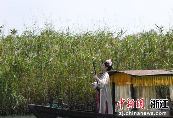 图为:汉服爱好者在芦苇荡前进行表演。中新社记者 王刚 摄