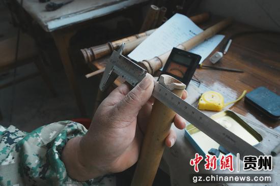 图为手艺人在进行长度测量。周燕玲 摄 图为手艺人在进行长度测量。周燕玲 摄