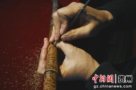 图为手艺人在箫笛上进行龙凤造型雕刻。周燕玲 摄 图为手艺人在箫笛上进行龙凤造型雕刻。周燕玲 摄