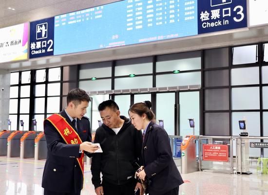 联合服务团队向旅客宣传“电子客票”并辅导开具(何博 摄) 联合服务团队向旅客宣传“电子客票”并辅导开具(何博 摄)