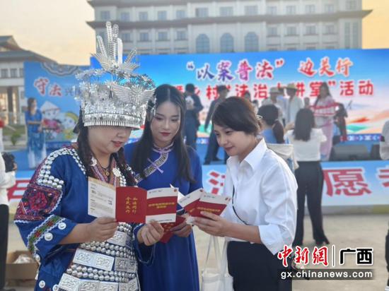 广西移动法务工作者向峒中群众普法。莫月萍 摄 广西移动法务工作者向峒中群众普法。莫月萍 摄