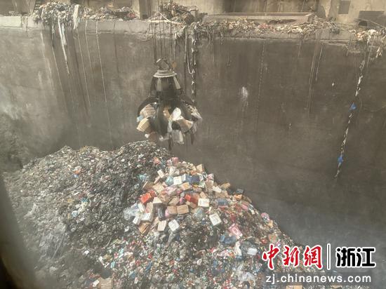 图为假冒伪劣卷烟从垃圾处理坑内被抓取。尚依雯 摄