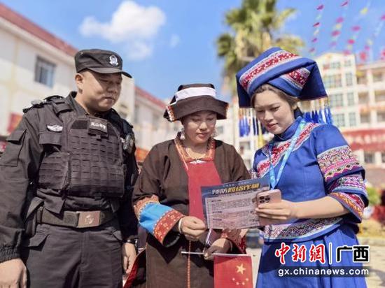 移动志愿者联合当地公安人员向瑶族群众讲解反诈常识。张艳秋 摄 移动志愿者联合当地公安人员向瑶族群众讲解反诈常识。张艳秋 摄