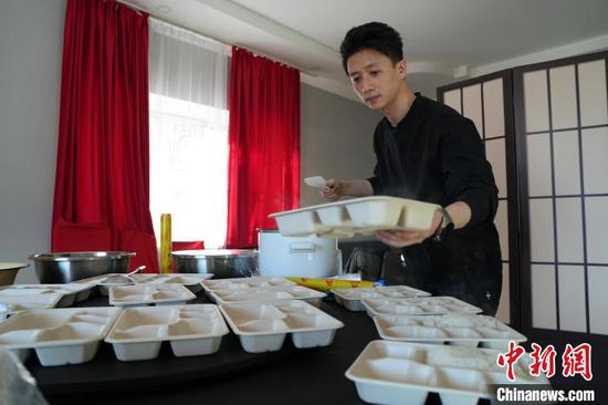 近日，哈萨克斯坦阿斯塔纳，贵州小伙王潇在打包外卖盒饭。　中新社记者 单璐 摄