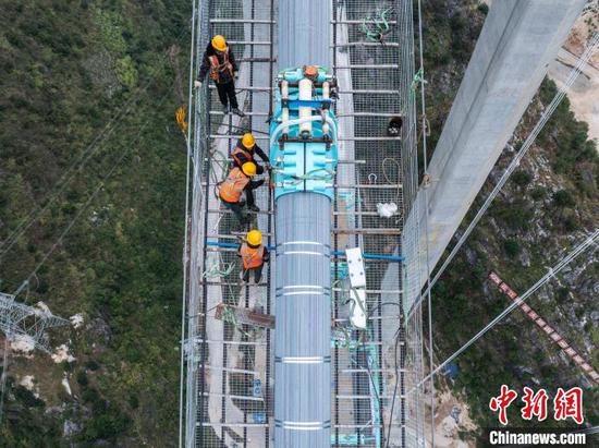 图为11月27日航拍工人在花江峡谷大桥项目建设现场施工。(无人机照片)中新社记者 唐哲 摄 图为11月27日航拍工人在花江峡谷大桥项目建设现场施工。(无人机照片)中新社记者 唐哲 摄