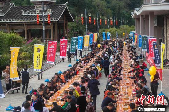 图为游客在侗族大歌节活动现场吃长桌宴。吴德军 摄 图为游客在侗族大歌节活动现场吃长桌宴。吴德军 摄