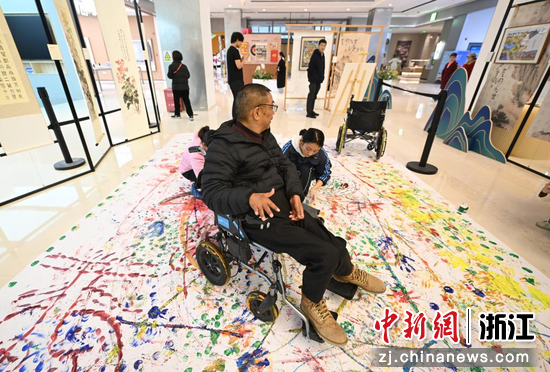 图为:残疾人体验轮椅作画。中新社记者 王刚 摄