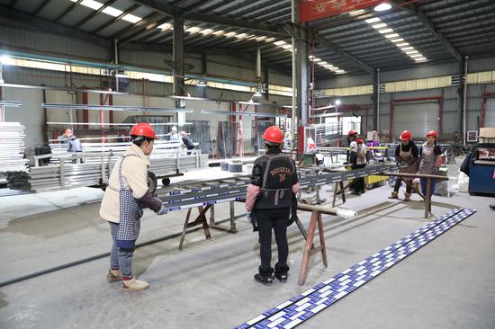 正在“帮扶车间”里忙碌的居民。李齐 摄