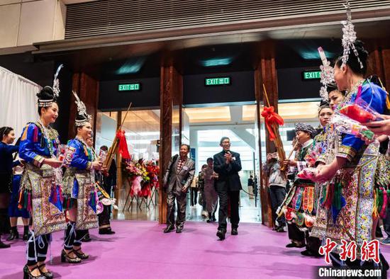 图为身着贵州省少数民族传统服饰的工作人员在展厅入口迎宾。中新网记者侯宇摄