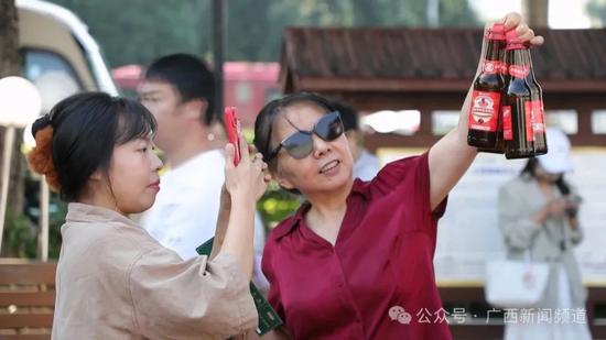 图为市民排队领取蔓越莓啤酒。来源:广西新闻频道 图为市民排队领取蔓越莓啤酒。来源:广西新闻频道