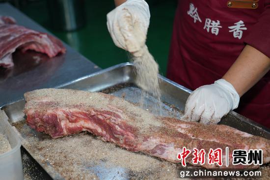 工作人员正在腌制腊肉。 沈建华 摄 工作人员正在腌制腊肉。 沈建华 摄