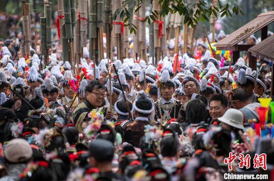 图为岜沙苗寨村民与游客在芦笙节活动上。吴德军 摄 图为岜沙苗寨村民与游客在芦笙节活动上。吴德军 摄