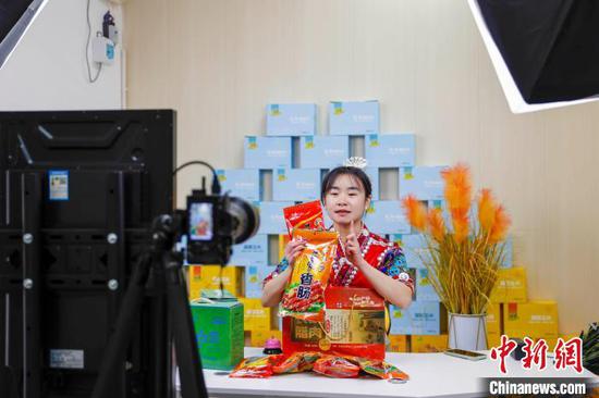 图为贵州施秉一主播在推介熏制的腊肉、香肠等特色农产品。磨桂宾 摄