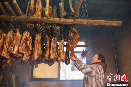 图为贵州施秉云台村一村民在查看腊肉熏制情况。磨桂宾 摄