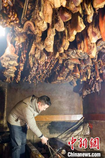 图为贵州施秉云台村一农家乐业主在熏制腊肉、香肠。磨桂宾 摄