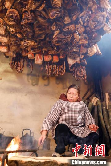 图为贵州施秉云台村一村民在熏制腊肉、香肠。磨桂宾 摄