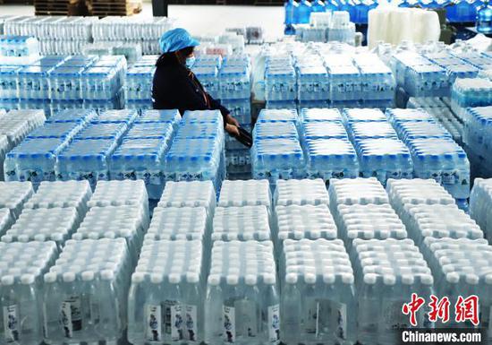 图为工人在搬运瓶装水。左禹华 摄