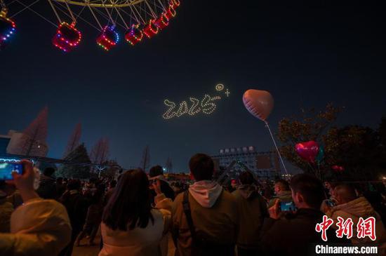 图为2024年12月31日晚，民众在贵州省贵阳市白云区白云公园内观看无人机倒计时表演迎接新年。中新社记者 唐哲 摄
