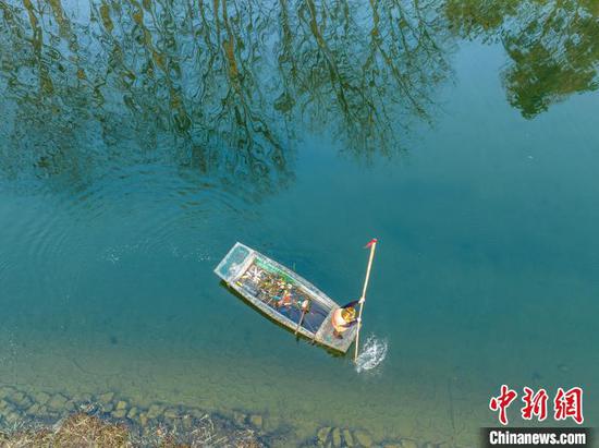 1月1日清晨，在毕节市碧阳湖附近的河道里，清洁工人在水面上进行河道清洁。罗大富 摄