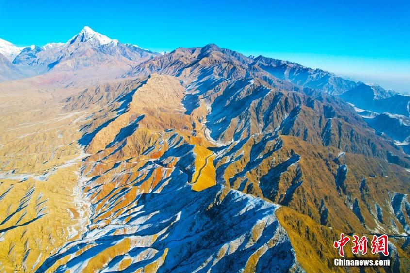 新疆阿克蘇：庫爾干山區(qū)雪后壯美巍峨 陽光下群山黃白相間