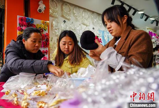 1月7日，市民在贵州省从江县一年货集市选购新春饰品。卢忠南 摄