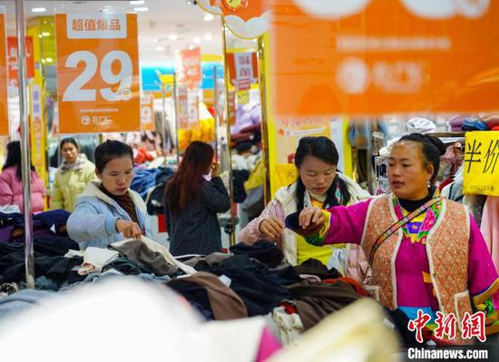1月7日，市民在贵州省从江县一服装商场选购新衣服。卢忠南 摄