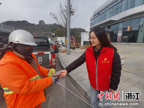 志愿者将腊八粥打包装好，送给环卫工人。康乾街道供图