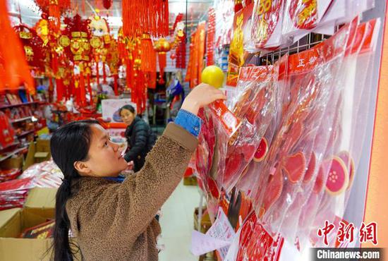 1月7日，市民在贵州省从江县一年货集市选购新春饰品。卢忠南 摄