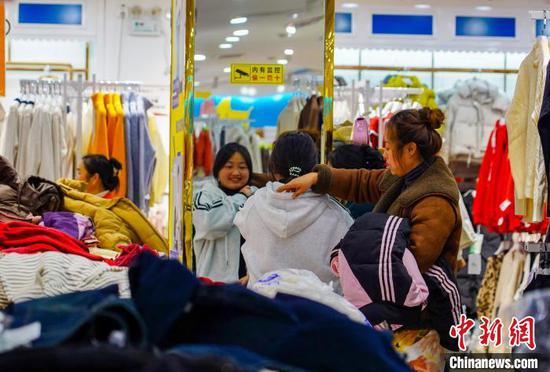 1月7日，市民在贵州省从江县一服装商场选购新衣服。卢忠南 摄