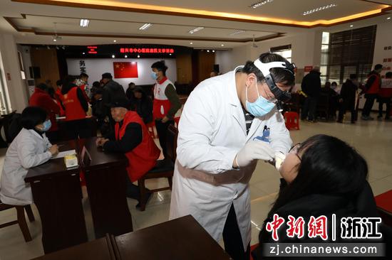 图为:医生为村民检查口腔。中新社发 单明铭 摄