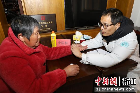 图为:医生为村民把脉。中新社发 单明铭 摄