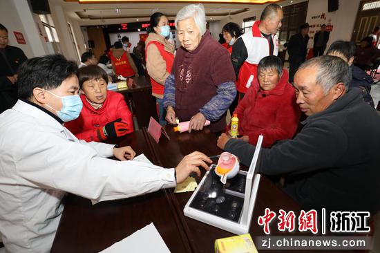 图为:医生为村民讲解眼睛知识。中新社发 单明铭 摄