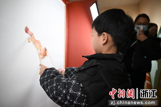 图为:孩童体验皮影戏。中新社记者 王刚 摄