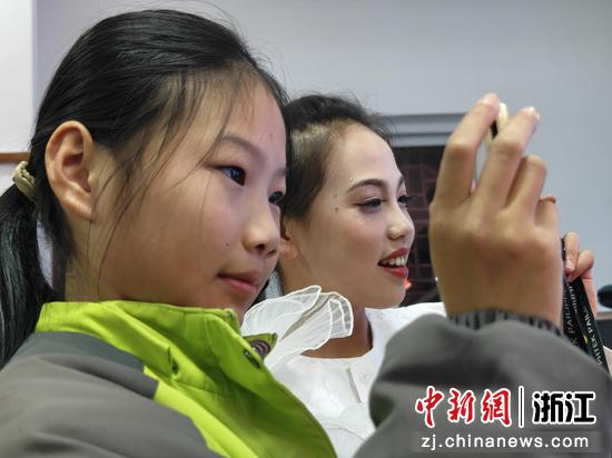 图为:东溪小学的学生高兴地用手机录制同学的演出。  中新社发 萧云集 摄