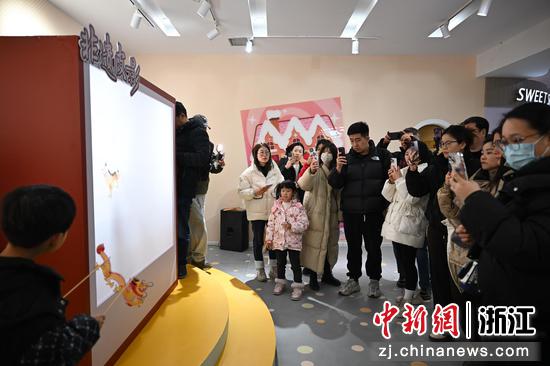 图为:孩童展示皮影戏吸引众人拍摄。中新社记者 王刚 摄