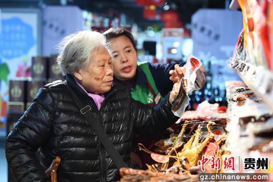 1月14日，在贵阳市南明区惠民生鲜合力超市南浦路店年货大街，市民正在选购腊味食品。