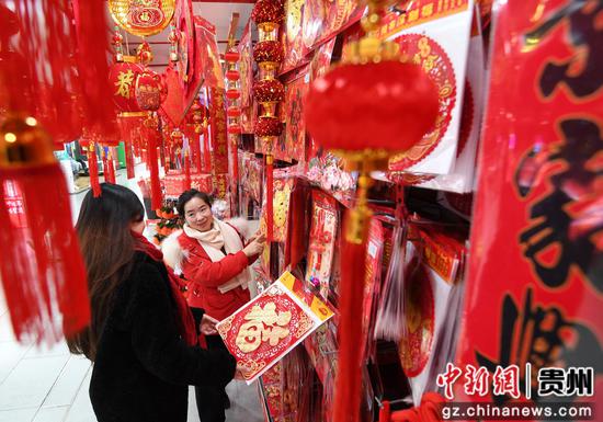 1月14日，市民正在贵阳市南明区惠民生鲜合力超市南浦路店年货大街选购新春饰品。
